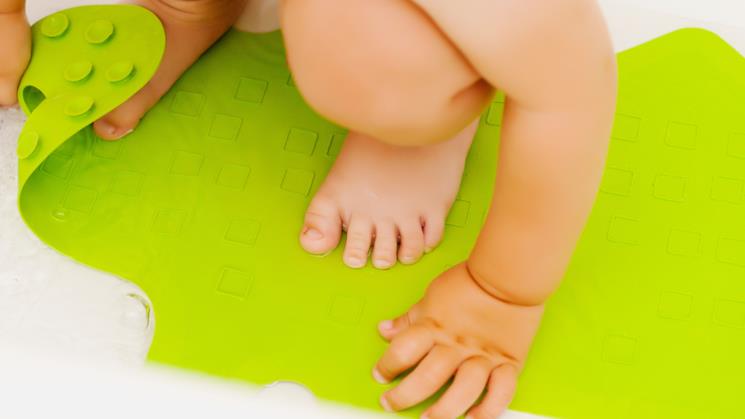 Bambino accovacciato su un tappeto antiscivolo 