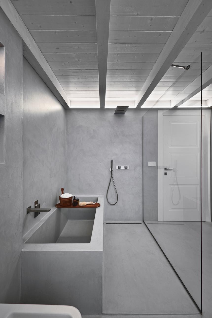 Bagno con pareti e pavimenti in microcemento grigi 