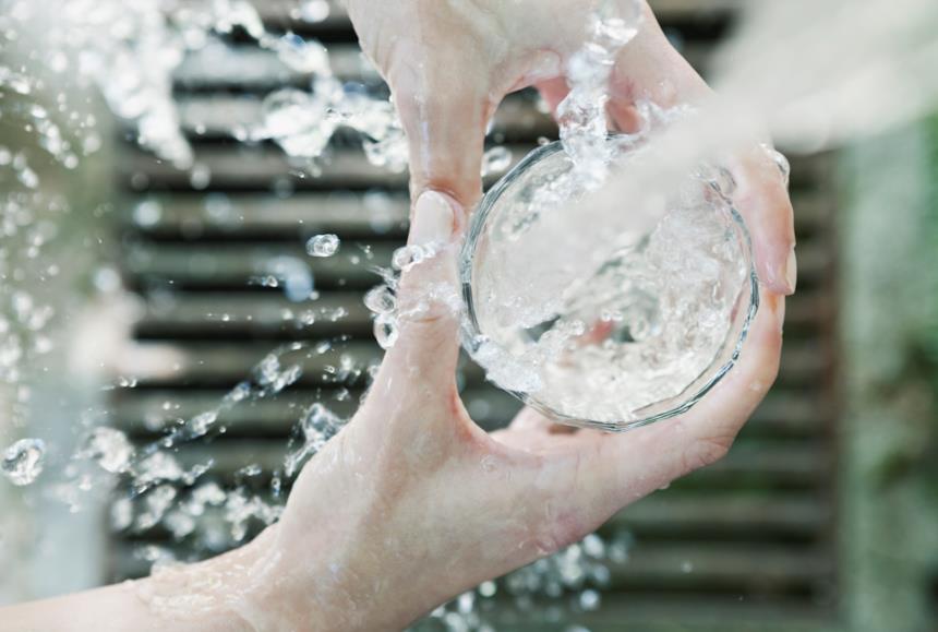 Acqua che scorre finendo in un bicchiere 