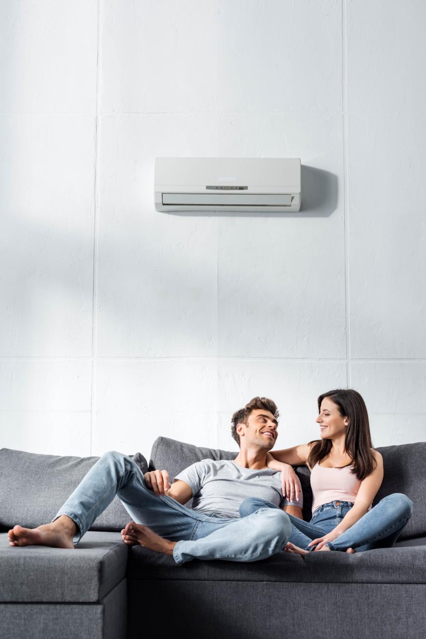 Coppia si rinfresca in sala con il climatizzatore 
