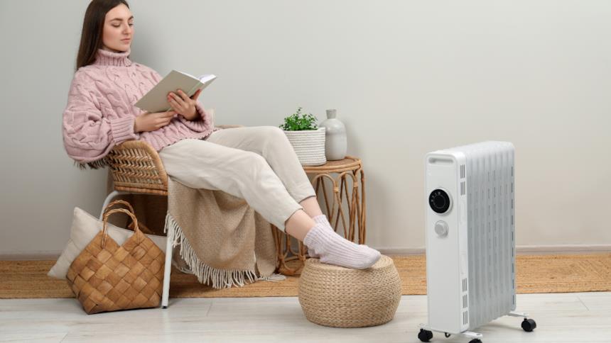 Donna legge vicino a una stufa elettrica portatile 