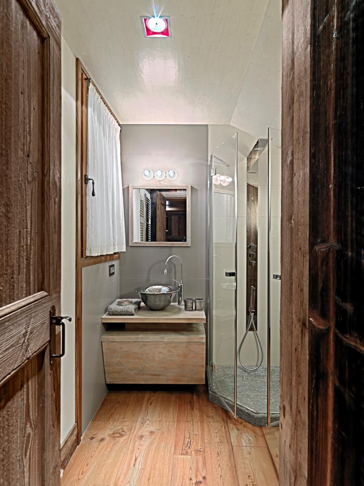 Bagno in camera con mobile portalavabo in legno e doccia 