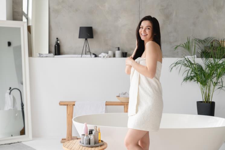 Donna in un bagno con vasca freestanding