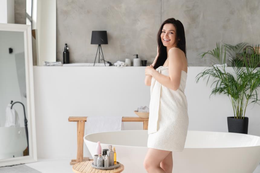 Donna in un bagno con vasca freestanding 