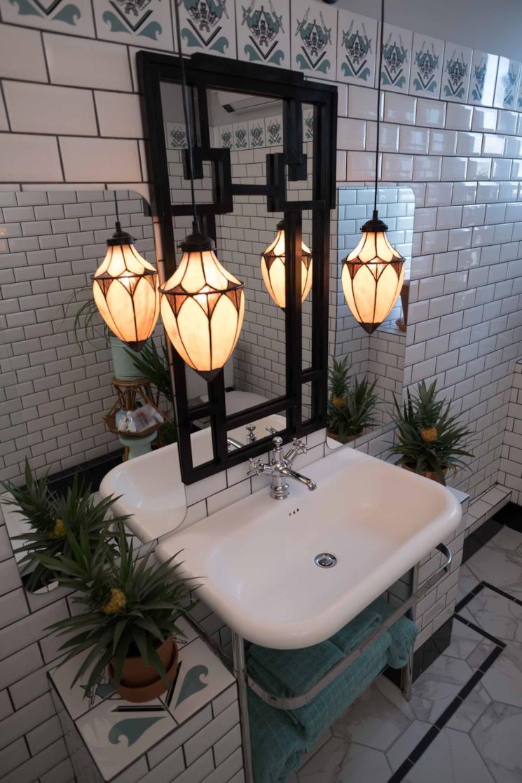 Bagno con piastrelle bianche e decorate