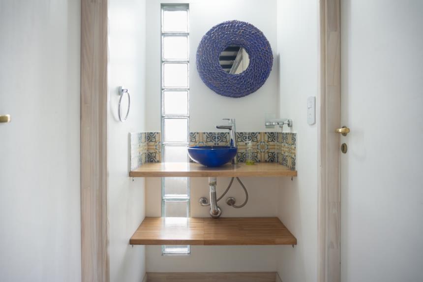 Bagno con console in legno, specchio e lavabo da appoggio blu 