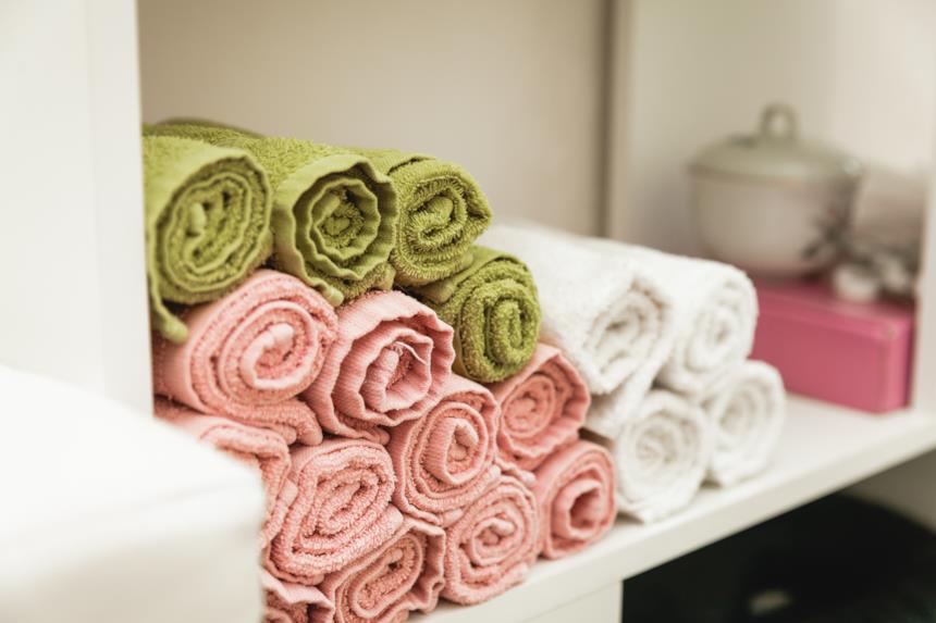 Asciugamani in bambù arrotolati su uno scaffale 