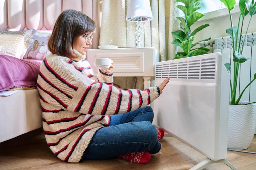 Donna si scalda con un radiatore in camera da letto 