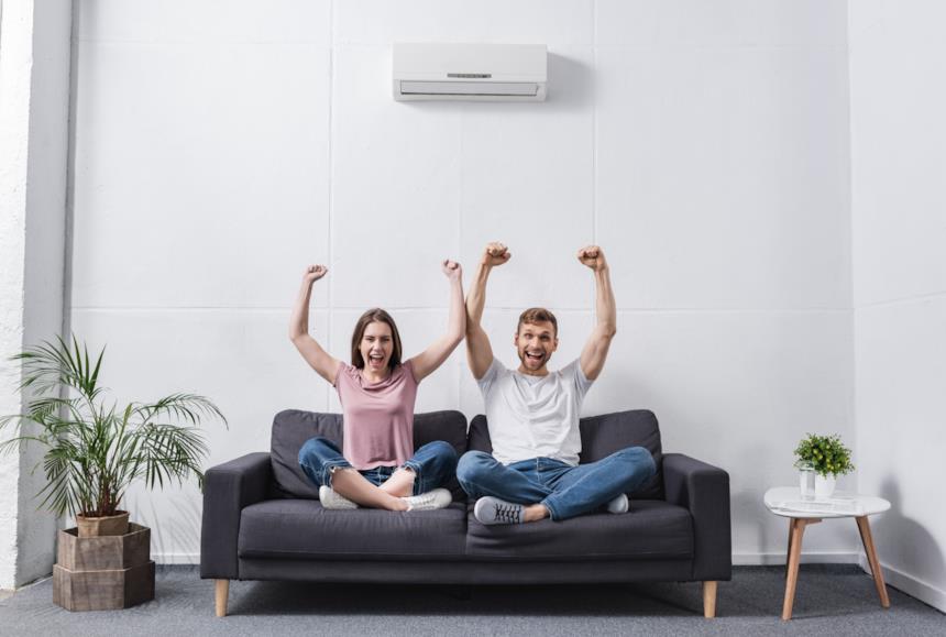 Coppia felice in soggiorno per via del climatizzatore 