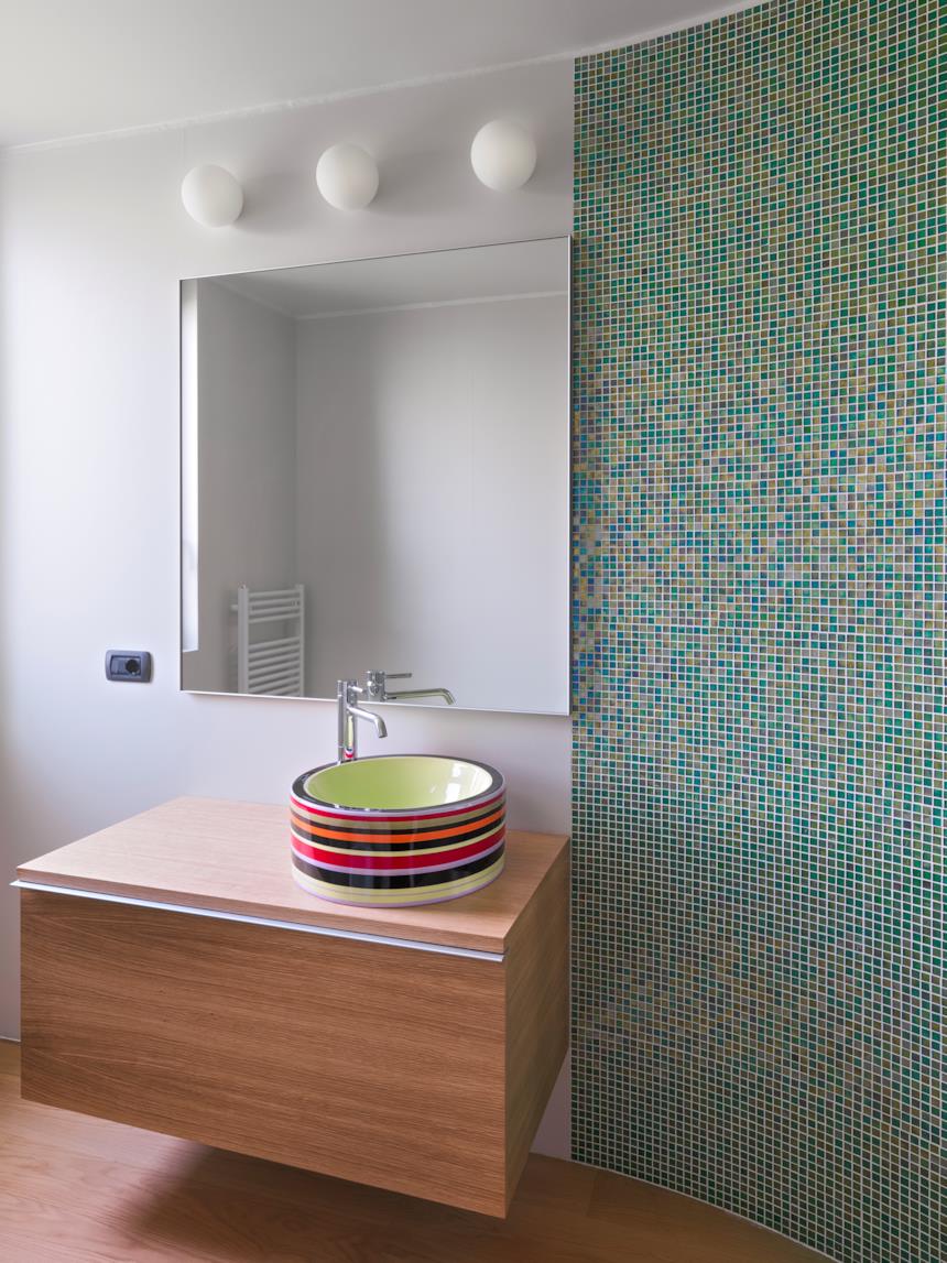 Mosaico applicato a una parete del bagno vicino il lavandino