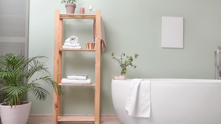 Bagno con vasca freestanding e credenza aperta con asciugamani