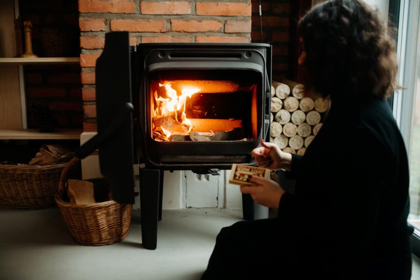 Donna davanti una stufa a legna