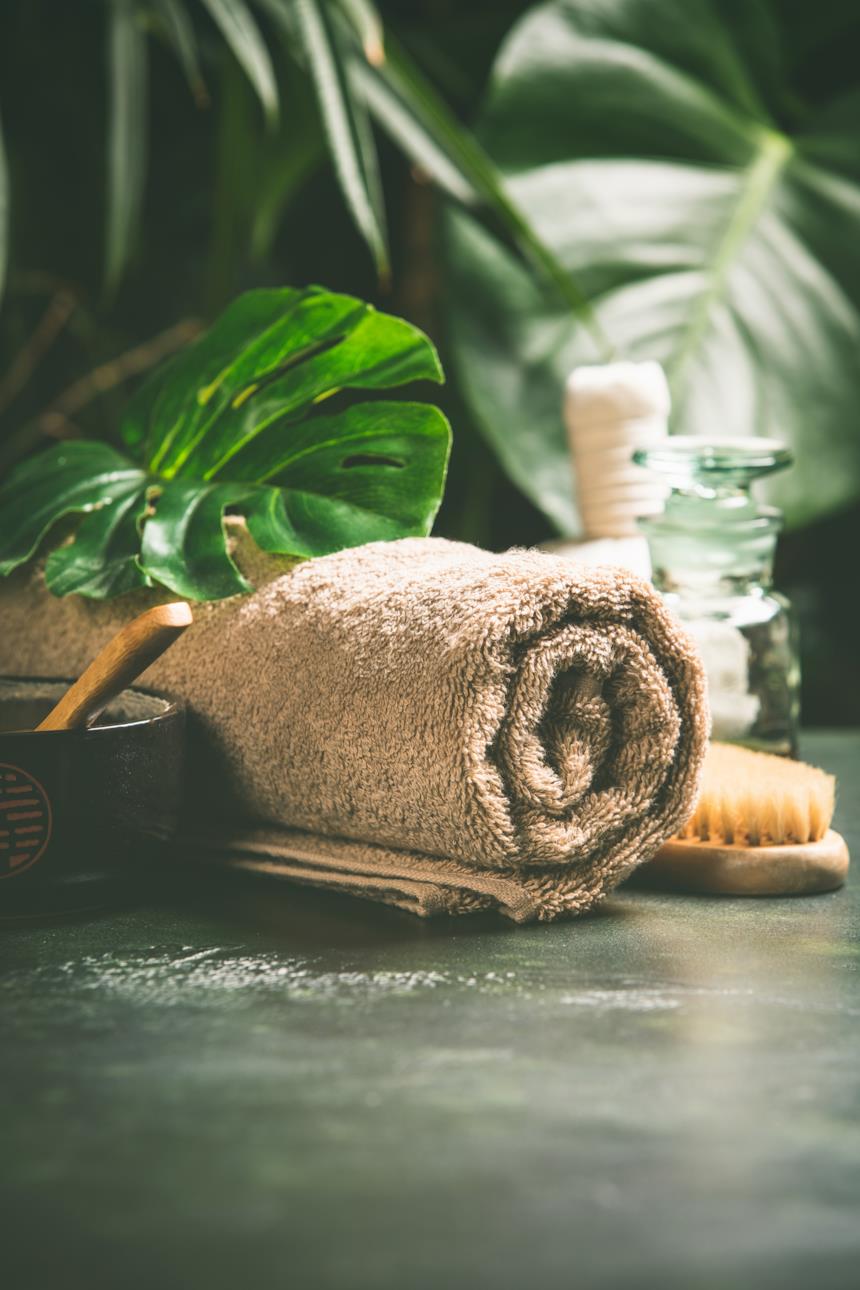 Asciugamano in bambù color caffellatte arrotolato su un ripiano