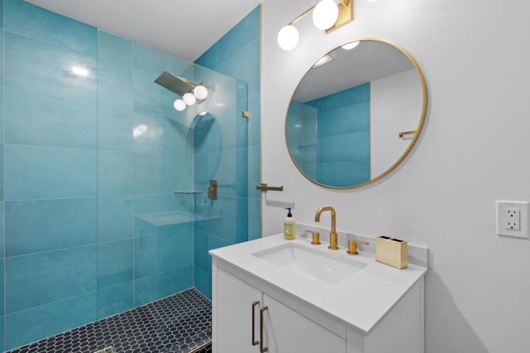 Bagno con interno doccia blu e mobile portalavabo bianco 