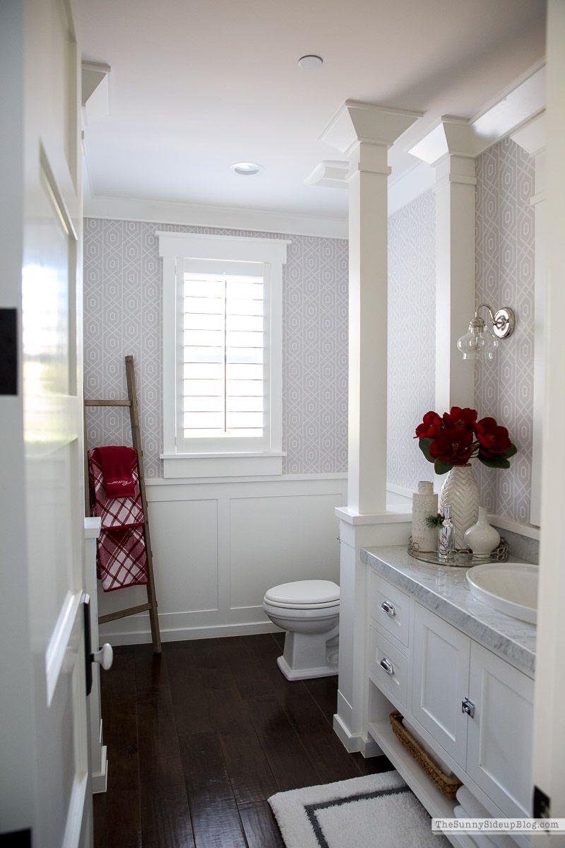 Foto di un bagno con asciugamani natalizi e una Stella di Natale in un vaso