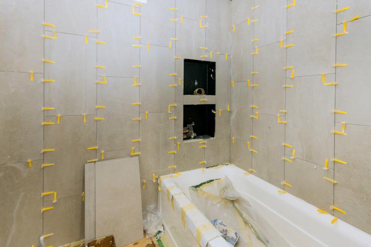 Zona della vasca da bagno con le piastrelle in posa