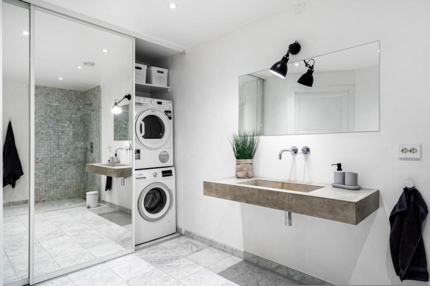 Foto di una lavatrice inserita all'interno di un armadio a muro con ante a specchio e scorrevoli