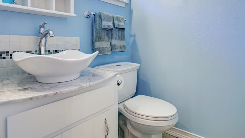 Bagno azzurro con mobili bianchi