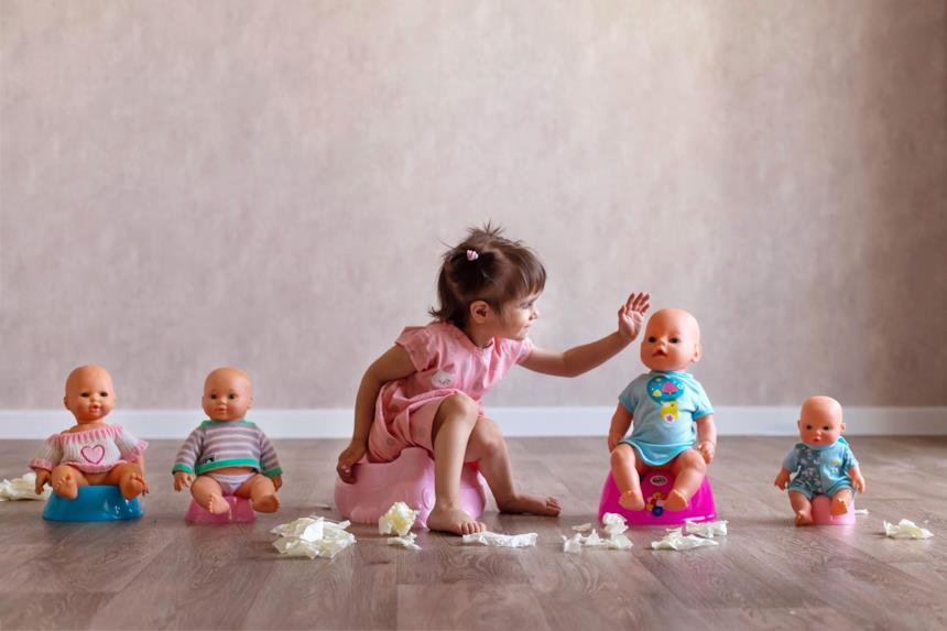 Bimba con vasino e bambole