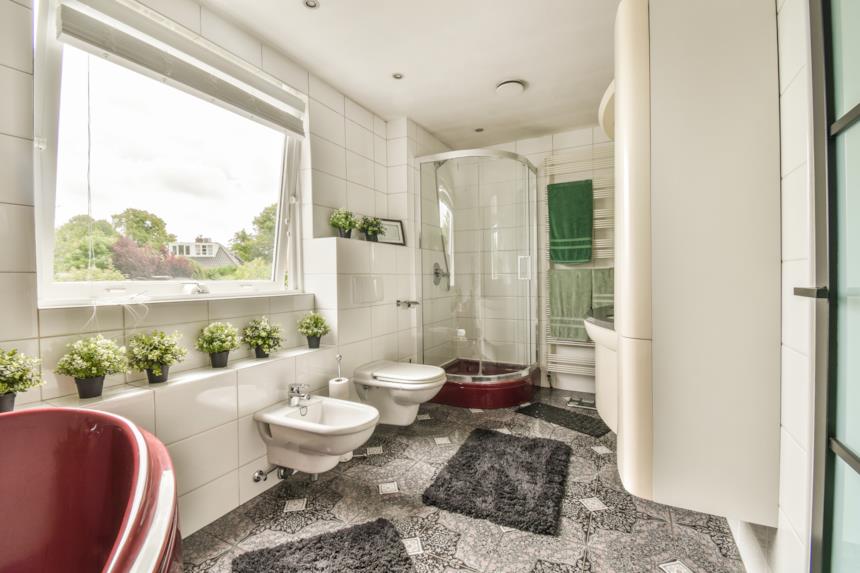 Bagno con WC e bidet affiancati, doccia angolare e vasca freestanding 