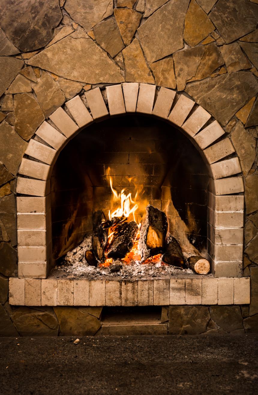 Camino in pietra con fuoco che arde 