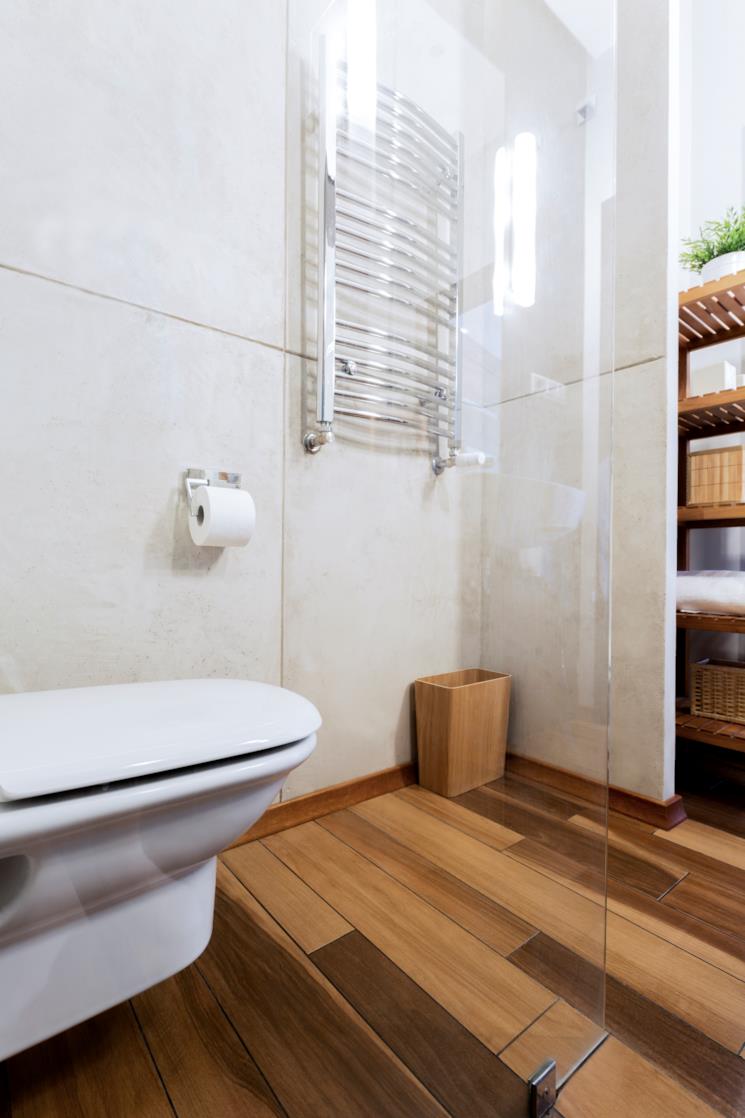 Cestino rettangolare in vimini in un angolo del bagno 