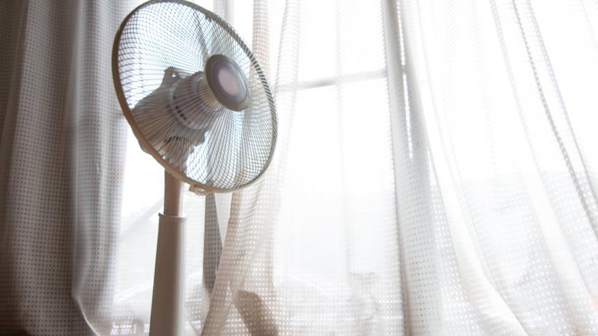 Ventilatore a piantana collocato vicino una finestra