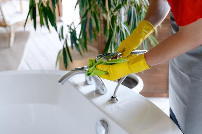 Donna pulisce la rubinetteria della vasca 