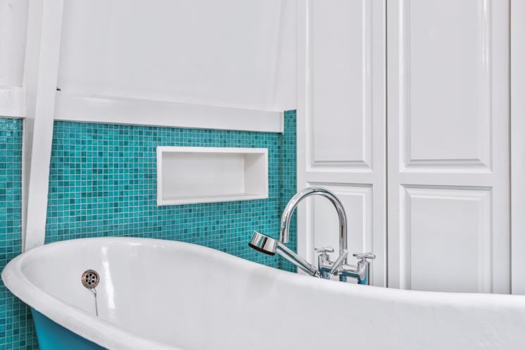 Mosaico usato come decoro della parete dietro la vasca freestanding retrò 