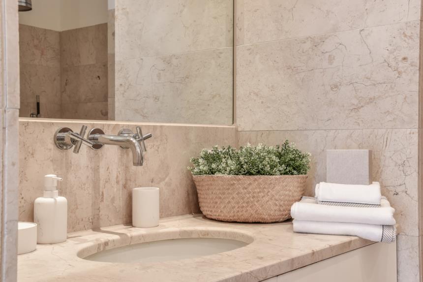 Lavello a incasso in marmo beige e rubinetteria a parete in acciaio 