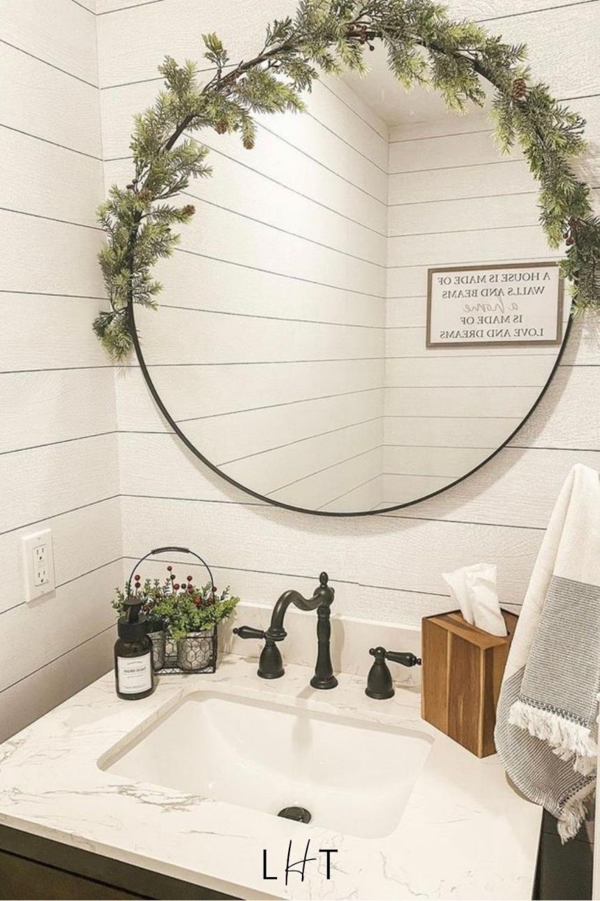 Foto dello specchio del bagno decorato con un ramo di pino