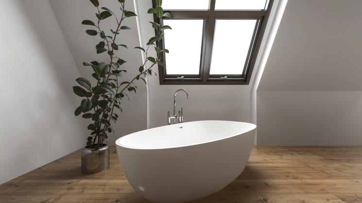 Bagno con vasca freestanding e parquet chiaro 