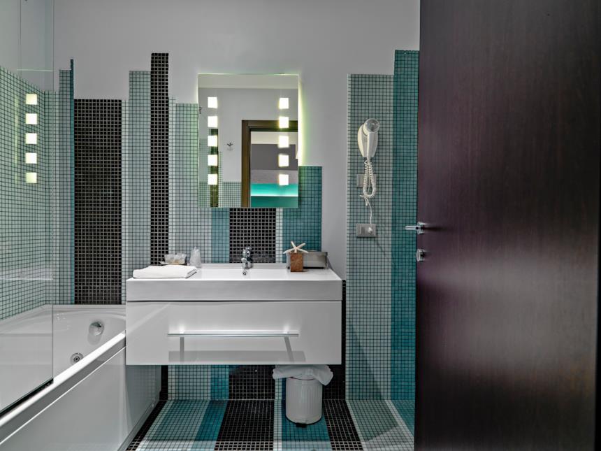 Bagno maschile con piastrelle a mosaico e mobile portalavabo bianco