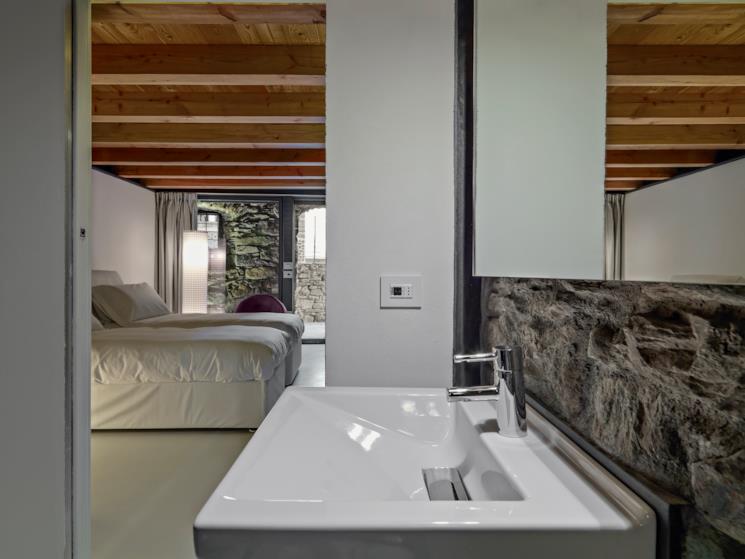 Lavandino in primo piano e sullo sfondo il letto 