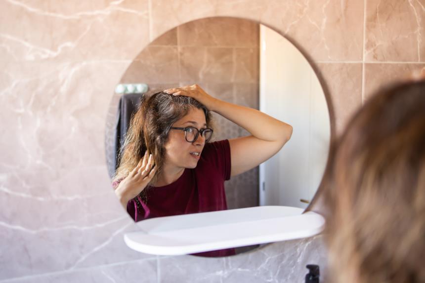 Ragazza si guarda allo specchio perplessa 