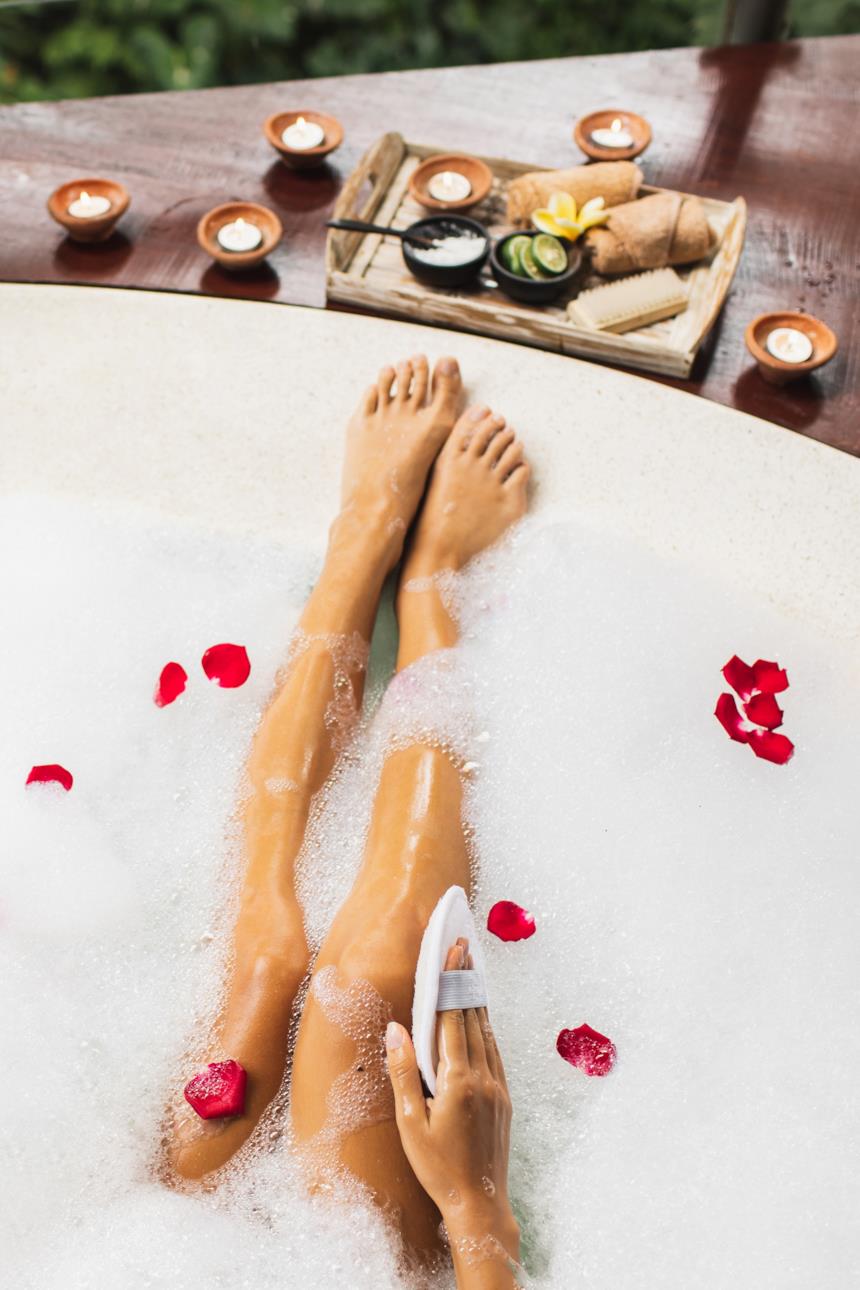 Donna esfoglia la pelle durante un bagno disintossicante 