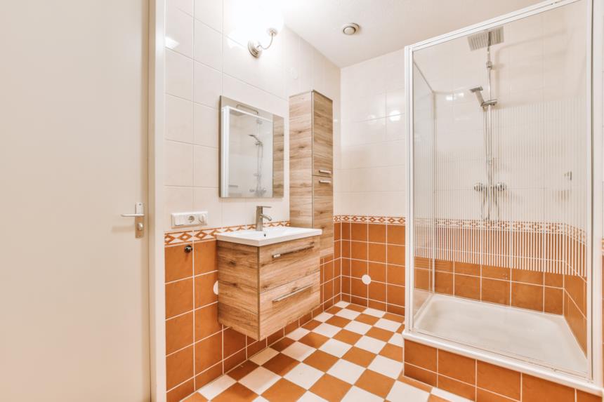 Bagno in tono arancione e mobili in legno