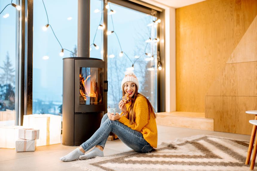 Ragazza mangia un biscotto davanti una stufa a legna 