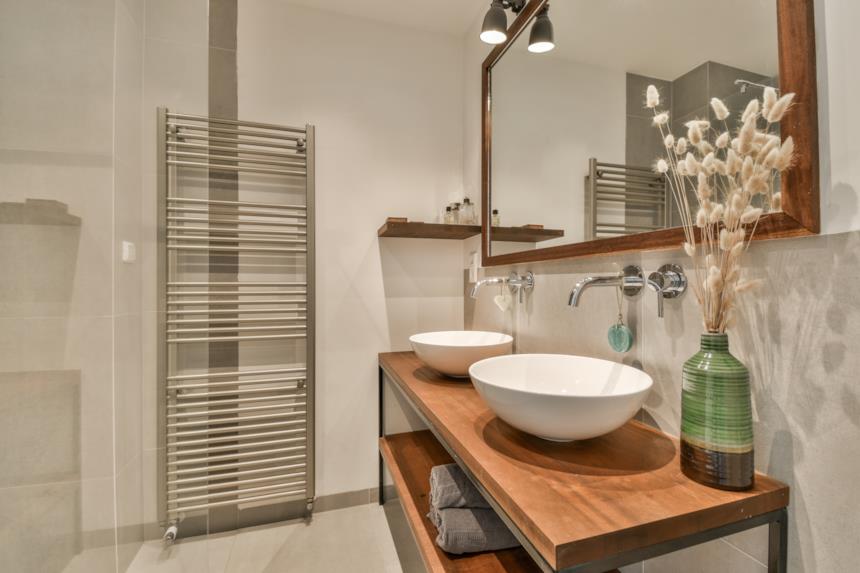 Coppia di lavabi da appoggio su mobile in legno con rubinetti a parete