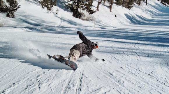 Sciatore con pantalone e giacca da snowboard