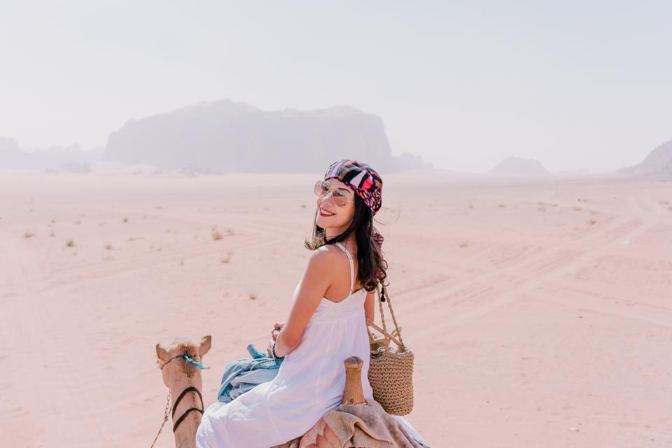 Woman riding a camel in Wadi Rum desert. Jordan