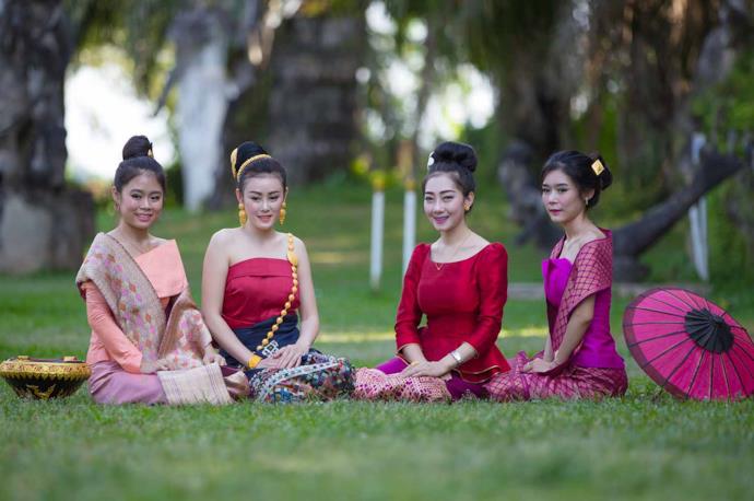 Laotian girls sitting on the grass in a park