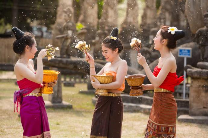 Three laotian girls celebrating with flowers