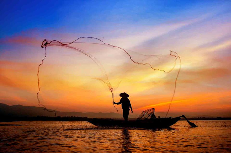 Pescatore in Cambogia al tramonto
