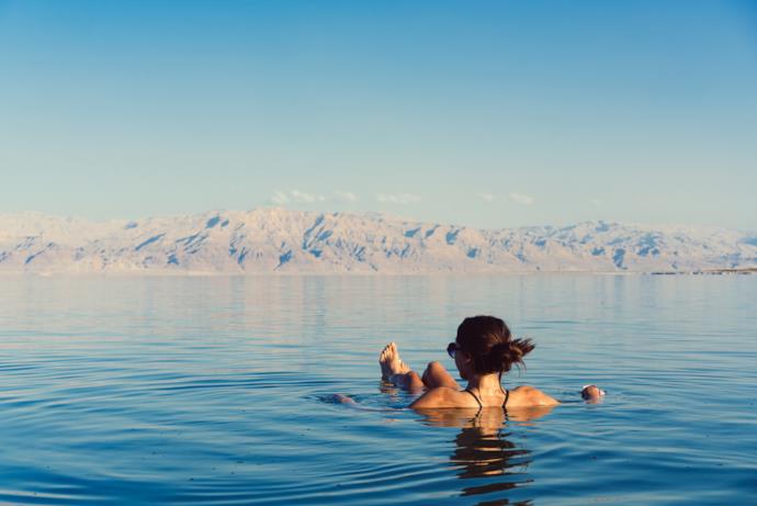 Donna che fa un bagno nelle acque del Mar Morto in Giordania