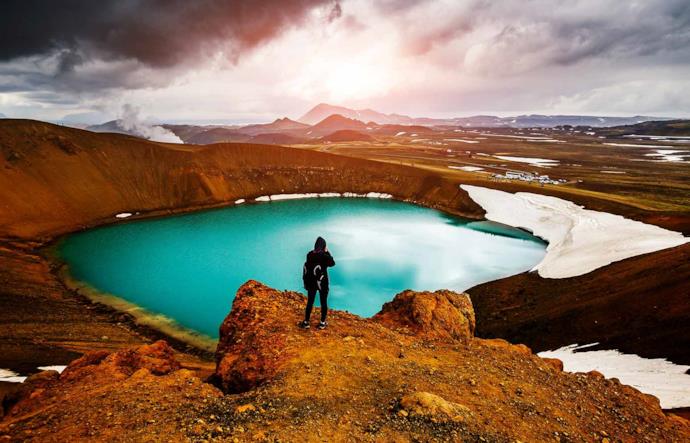 Viaggiatore ammira lago in Islanda nella valle Leirhnjukur