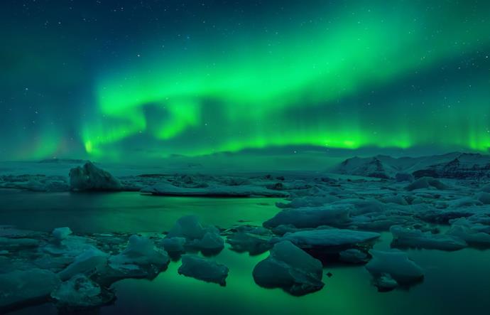 Aurora boreale notturna su ghiacciaio in Islanda