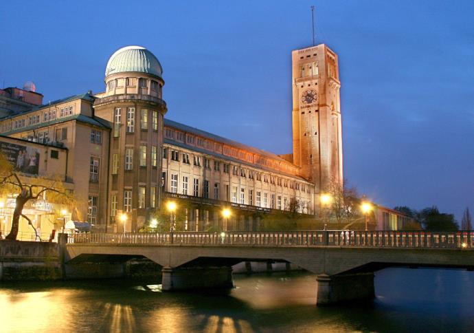 Il Deutsches Museum lungo il fiume Isar illuminato dalle luci della sera.